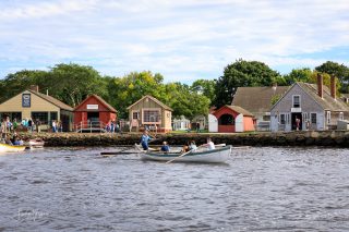 visitors row a whaleboat in the water by Mystic Seaport Museum